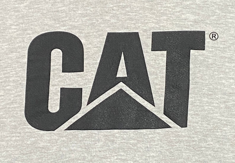 May include: Black and white logo of the word "CAT" with a black triangle in the center. The logo has a registered trademark symbol.