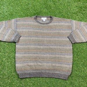 Könnte beinhalten: Ein gestreifter Pullover in Braun, Beige und Blau mit einem Rundhalsausschnitt.