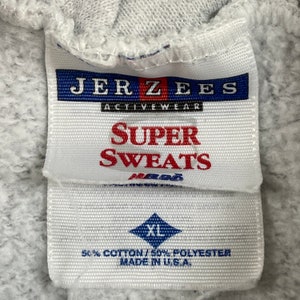 May include: A white tag with blue and red text that reads "JER ZEES ACTIVEWEAR SUPER SWEATS" and a blue diamond with the text "XL" and the text "50% COTTON/50% POLYESTER MADE IN U.S.A."