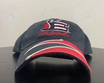 Könnte beinhalten: Schwarze Baseballkappe mit einem rot-weiß-schwarzen gestreiften Schirm. Die Vorderseite der Kappe zeigt ein gesticktes Logo in Schwarz und Weiß mit dem Text "Dale Earnhardt Jr." in Rot.
