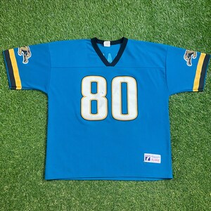 May include: A blue football jersey with the number 80 on the front. The jersey has black and gold trim and a black collar. The jersey is a size XL.