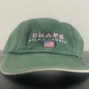 May include: A green baseball cap with a white brim and the embroidered text "CHAPS RALPH LAUREN" and a small American flag.