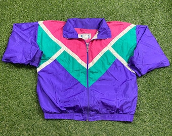 May include: A purple, pink, green, and white windbreaker jacket with a zipper closure. The jacket has a chevron pattern.