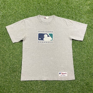 May include: Gray t-shirt with a Seattle Mariners baseball logo and the text "Mariners Baseball". The shirt has a tag that says "Authentic", with a Mariners logo.