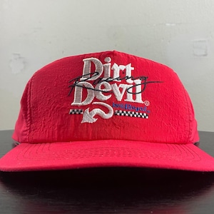 Peut inclure: Casquette de baseball rouge avec un logo brodé blanc qui dit "Dirt Racing Devil by Best Royal".
