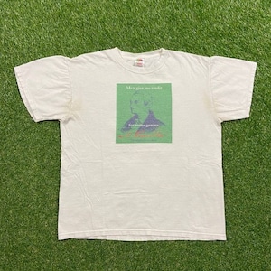 May include: White t-shirt with a green rectangle featuring a portrait of a man and the text "Men give me credit for some genius. -  Leonard Bernstein".