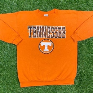 May include: Orange long-sleeve sweatshirt with the text "Tennessee" and a white "T" in a circle on the front.