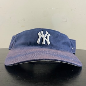 Peut inclure: Une visière bleu marine avec un logo brodé blanc des New York Yankees.