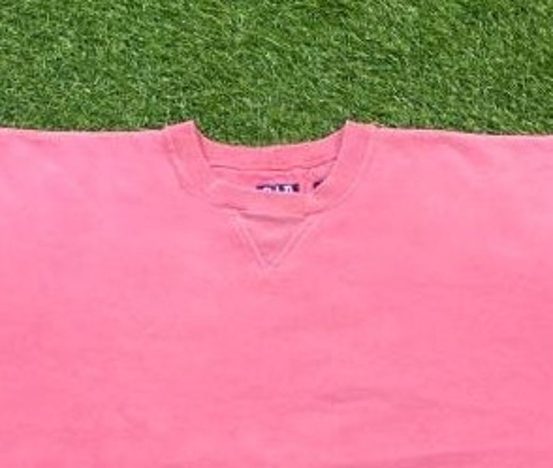 May include: A pink crew neck sweatshirt with a small tag on the front that says "Old Navy".