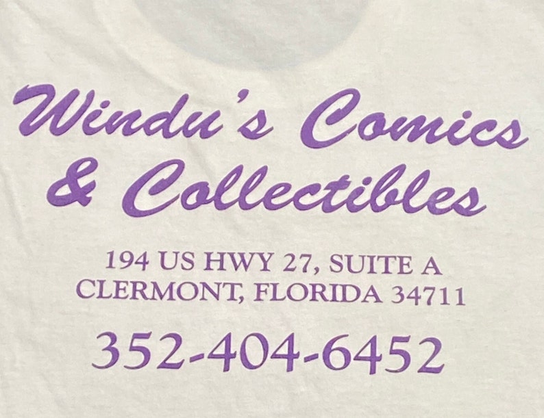 Op de afbeelding: Paarse tekst op een witte achtergrond met de tekst "Windu's Comics & Collectibles", "194 US HWY 27, SUITE A", "CLERMONT, FLORIDA 34711" en "352-404-6452".