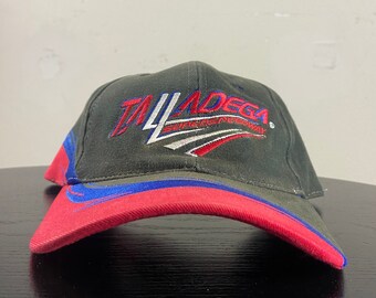 Könnte beinhalten: Eine schwarze, rote und blaue Baseballkappe mit dem gestickten Text "Talladega Superspeedway".