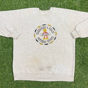 May include: A gray sweatshirt with a graphic of a cartoon character with the text "Energized & Ready We Are Potomac Edison".