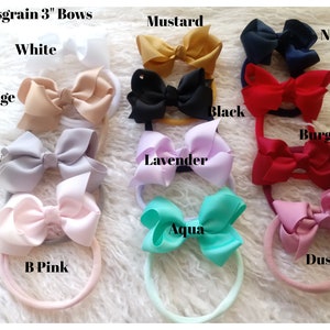 May include: Ten different colors of 3-inch grosgrain ribbon bows attached to elastic headbands. The colors are white, beige, grey, baby pink, mustard, navy, red, burgundy, lavender, and aqua.