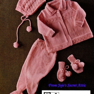 May include: A pink knitted baby outfit set with a hat, cardigan, pants, and mittens. The set is made using double knitting and is available in sizes 16 to 20. The pattern is from Jojo's Secret Attic.