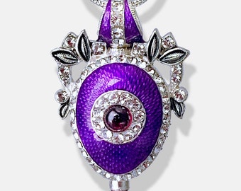 Colgante de huevo de Fabergé de plata de ley con forma de ojo malvado: esmalte morado, granate y cristal.