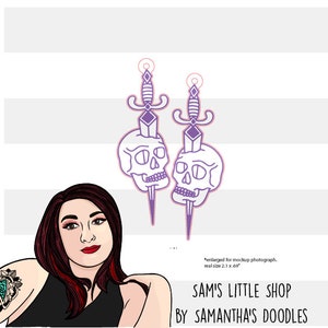 May include: A pair of purple skull and dagger earrings. The earrings are approximately 2.1 inches tall and 0.69 inches wide.