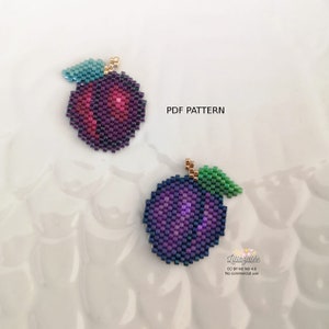 Puede incluir: Dos abalorios de ciruela con hojas verdes. Las ciruelas son moradas y azules con un ligero brillo iridiscente. Las hojas son verdes con un centro azul claro. Los abalorios están sobre un fondo blanco con el texto "PDF PATTERN" y "Lillagalée CC BY NC ND 4.0 No commercial use" en la esquina inferior derecha.