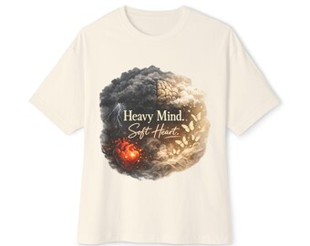 Op de afbeelding: Crèmekleurig T-shirt met een grafisch ontwerp. Het ontwerp bevat de tekst "Heavy Mind.. Soft Heart", een hersen, hart, vlinders en onweerswolken. Het shirt is gemaakt van een zacht materiaal.