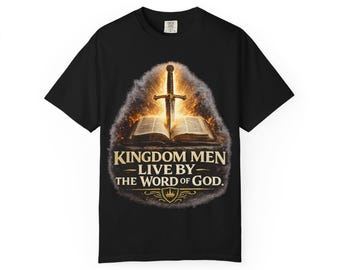 Op de afbeelding: Zwart t-shirt met een grafisch ontwerp met een zwaard, een open boek en de tekst "KINGDOM MEN - LIVE BY - THE WORD OF GOD." Het ontwerp heeft gouden en witte accenten, met een schild en een kroon.