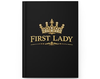 Op de afbeelding: Zwart notitieboek met gouden tekst en een gouden kroonontwerp. De tekst luidt "FIRST LADY". De kroon is gedetailleerd met juwelen. Het notitieboek heeft een matte afwerking.