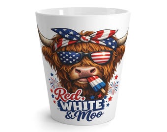 Op de afbeelding: Witte keramische latte mok met een cartoon Highland koe met een zonnebril in de stijl van de Amerikaanse vlag en een rood, wit en blauw ijsje. De mok heeft de tekst "Red, White & Moo".