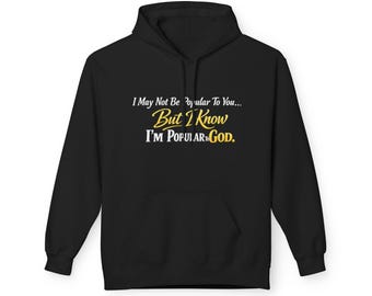 Op de afbeelding: Zwarte hoodie met een voorzak. De tekst op de hoodie luidt: "I May Not Be Popular To You... But I Know I'M POPULAR TO GOD" in witte en gele letters.