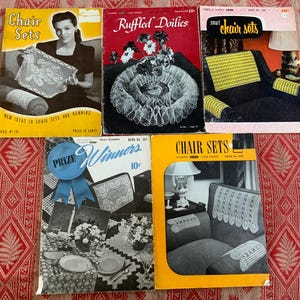 May include: Four vintage crochet pattern books with yellow covers. The books feature images of chair sets, doilies, and runners. The titles of the books are "Chair Sets", "Ruffled Doilies", "Smart Chair Sets", and "Chair Sets".