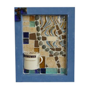 May include: A mosaic artwork featuring a coffee cup and coffee beans. The artwork is set within a blue frame. The mosaic background incorporates various colors and textures, including beige, brown, blue, and gold tiles, and small stones.