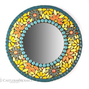 May include: A round mirror with a mosaic frame of yellow, orange, and blue flowers. The frame is made of small ceramic tiles.