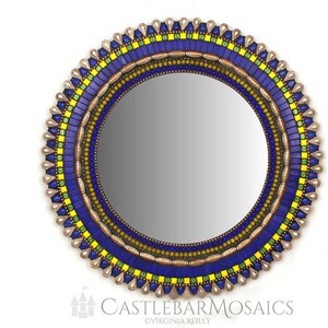 May include: Round mirror with a mosaic frame in shades of blue, yellow, and gold. The frame features a repeating pattern of small squares and beads.