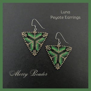 Puede incluir: Un par de pendientes Luna Peyote. Estos pendientes triangulares presentan un diseño geométrico en tonos verdes, negros y dorados. Los pendientes están suspendidos de ganchos plateados. El texto "Merry Beader" está en la parte inferior.