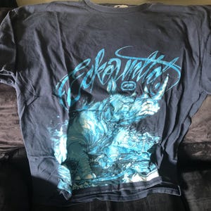 May include: A dark blue t-shirt with a graphic of a blue rhinoceros in water. The text "ecko unltd" is written in white on the shirt.