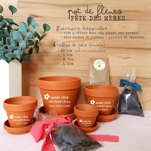 Peut inclure: Ensemble de quatre pots de fleurs en terre cuite avec le texte "Bonne Fête Maman" en blanc. Les pots sont de différentes tailles : XS (6 cm), S (8 cm), M (11 cm) et L (13 cm).