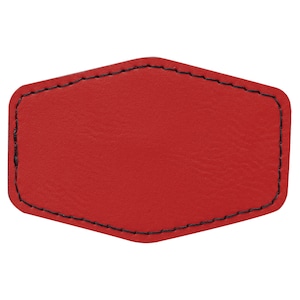 Puede incluir: Un parche de cuero rojo con costuras negras, con forma de hexágono con bordes redondeados.