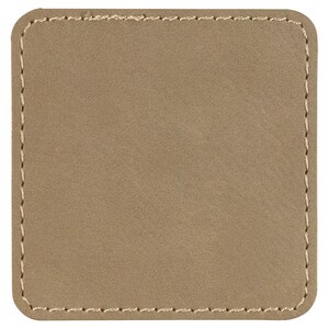 Puede incluir: Un parche de cuero beige con un borde cosido.