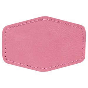 Puede incluir: Un parche de cuero rosa con un borde cosido. El parche está en blanco y listo para personalizar.