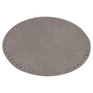 May include: A grey oval-shaped leather patch with a stitched edge.
