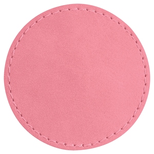 May include: A circular pink coaster with a stitched border. The coaster is a solid pink colour and has a simple design. The stitching is a lighter pink and follows the edge of the coaster, which is approximately 10 cm in diameter.