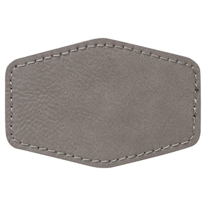 May include: A gray leather patch with a stitched edge. The patch is blank and can be used for a variety of purposes.