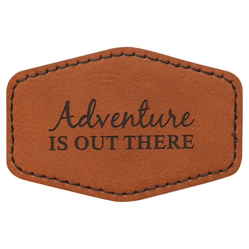 May include: A brown leather patch with stitched edges and the text "Adventure is out there" in black.