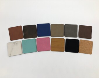 May include: A collection of 12 square samples of different materials, including cork, wood, marble, and suede. The samples are arranged in a row on a white background.