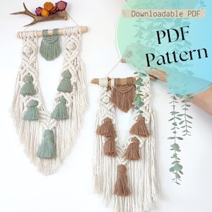 Puede incluir: Dos tapices de macram&eacute; de pared con borlas. El de la izquierda tiene borlas verdes y el de la derecha tiene borlas marrones. Ambos tapices est&aacute;n hechos con cord&oacute;n blanco y tienen una varilla de madera en la parte superior. El texto "Downloadable PDF PDF Pattern" est&aacute; en la esquina superior derecha de la imagen.