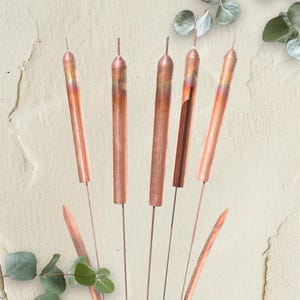 May include: Copper-colored metal decorative stems with a natural, organic aesthetic. The stems are arranged in a bouquet-like fashion, with a few leaves and the words "Friends Forever" in a script font.