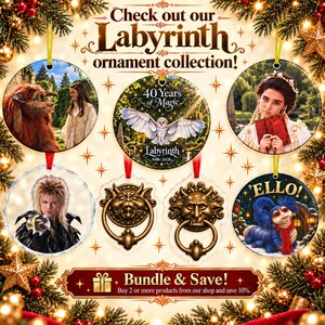 May include: A collection of round Labyrinth themed ornaments featuring characters and scenes from the film, including Jareth with a crystal ball, a barn owl, a worm with a red scarf, and bronze door knockers, all displayed with festive holiday decor.