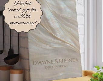 May include: A rectangular glass cutting board with a pearlescent, wavy cream and white surface. The text reads: DWAYNE & RHONDA 30TH ANNIVERSARY. A decorative scalloped label on the left reads: Perfect "pearl" gift for a 30th anniversary!