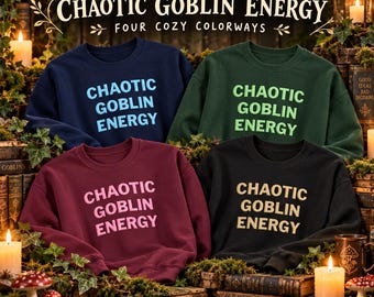 May include: Four crewneck sweatshirts in navy blue, dark green, maroon, and black. Each features the text "CHAOTIC GOBLIN ENERGY" in a contrasting color. The navy sweatshirt has light blue text, green has lime, maroon has pink, and black has yellow.