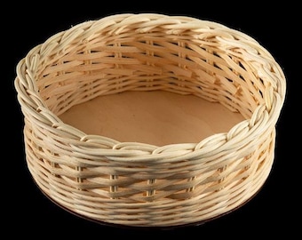 May include: A round, woven wicker basket with a natural wood finish. The basket has a flat bottom and is perfect for storing small items.