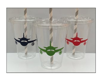 May include: Three clear plastic cups with striped paper straws. Each cup has a different colored airplane sticker on the front: blue, green, and red.
