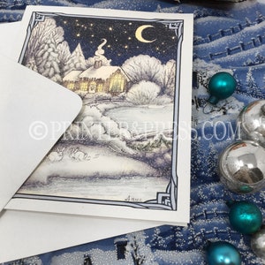 May include: A snowy winter scene with a small cottage, trees, and two rabbits in the foreground. The sky is dark blue with stars and a crescent moon. The cottage has a warm glow coming from the windows. The image is framed with a decorative border.