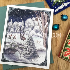 May include: A snowy winter scene with a group of people ice skating on a frozen pond. The scene is framed by a dark gray border and includes a large snow-covered tree in the foreground. The sky is dark blue with white stars and falling snow.
